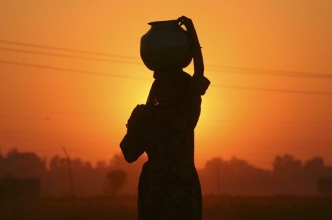 A Gujjar or nomad woman carrying a pitcher filled with drinking water is silhoue