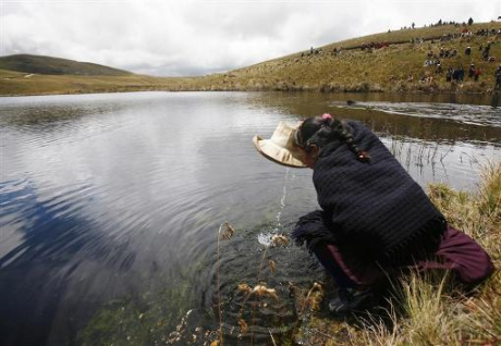an andean woman drinks water from the cortada an andean woman drinks water from the cortada